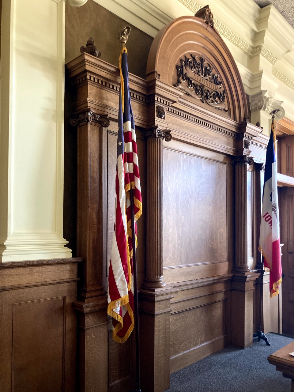 Crawford County Courtroom wall paneling and American and Iowa flags.